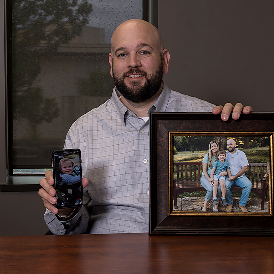 Ryan Curtis holding family photos