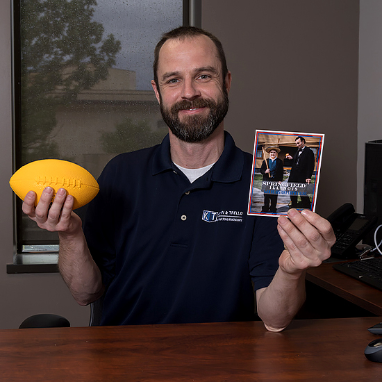Phil Weber holding a football and Illinois card
